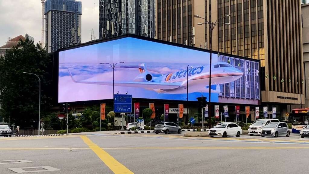 City building façade integrated with transparent LED film screens showing dynamic advertising content.