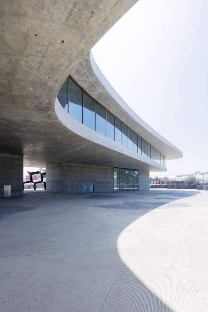 Street-level perspective showing the elevated museum and shaded public areas beneath.