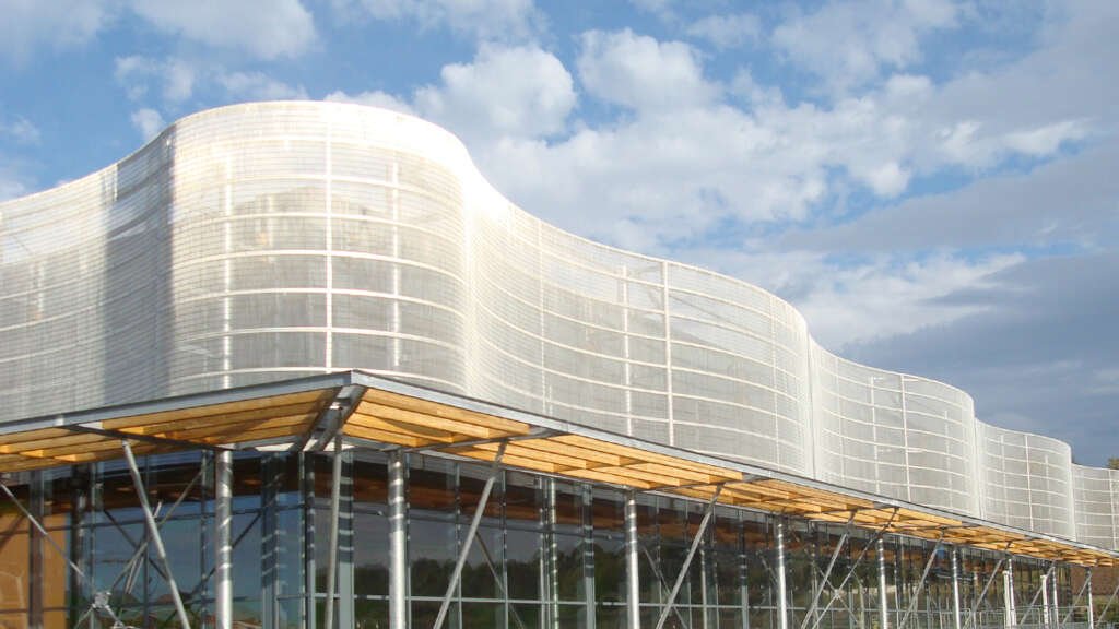 Rolling stainless steel wire mesh facade at Centre Aquatique, Vic-le-Comte, France. Image Courtesy of Haver & Boecker