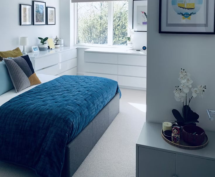 blue bed linen near white wooden framed glass window