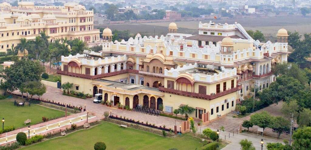 Laxmi palace-hotel in Bharatpur features Mughal-style gardens and Rajput architecture with sprawling courtyards, latticework windows, and multifoil arches.