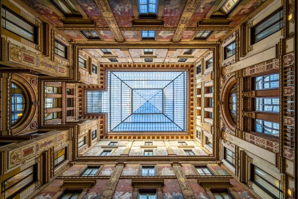 Glass vault roof covered by ornately painted walls of Galleria Sciarra