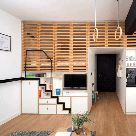 Workspace in a studio apartment featuring a wall-mounted desk and floating shelves to maximize space and organization