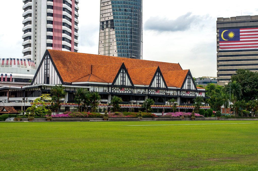 exterior view of royal selangor club with a grassy front lawn and dominant red tiled roof
