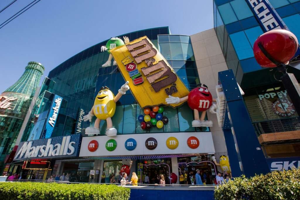 The M&M's World store in Las Vegas with its eye-catching facade, featuring large M&M characters, a giant chocolate bar, and a modern design.