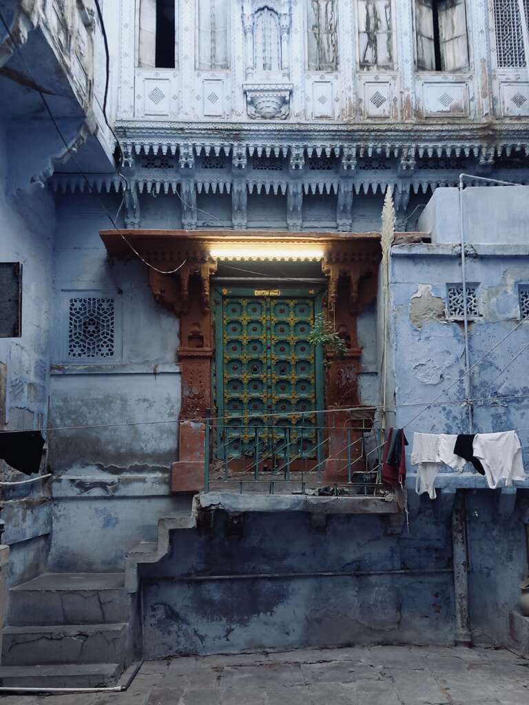 haveli painted in blue with a wooden main door and weathered finish
