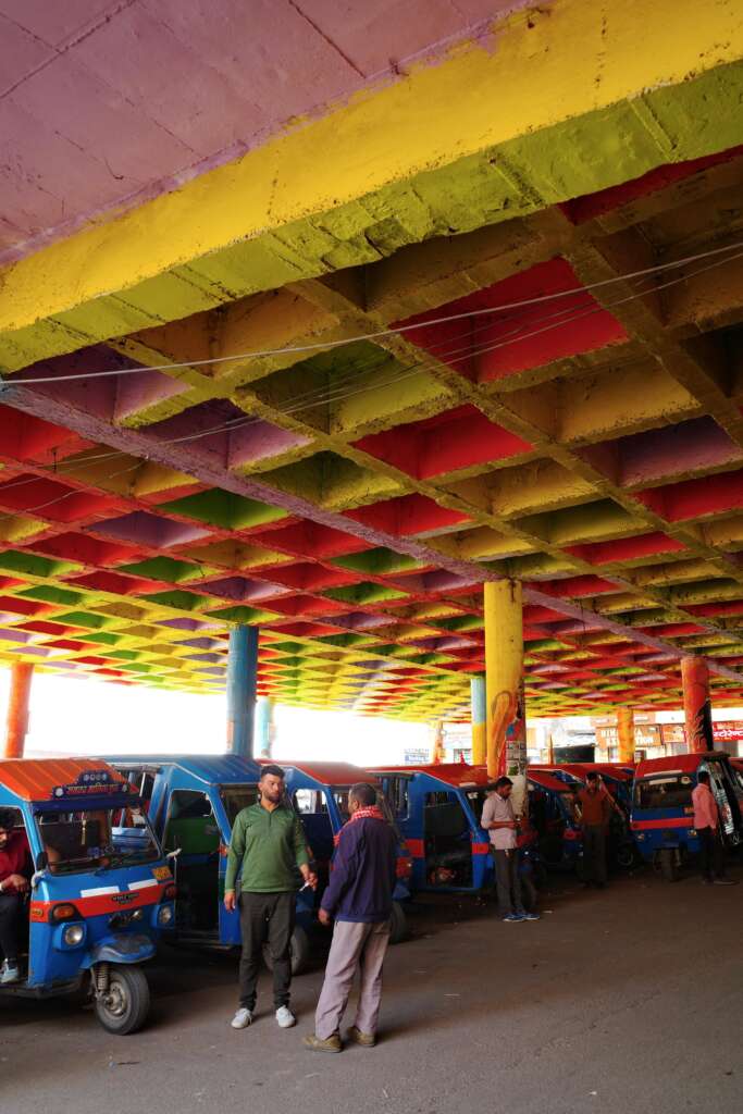 space below a flyover used for parking of rickshaws