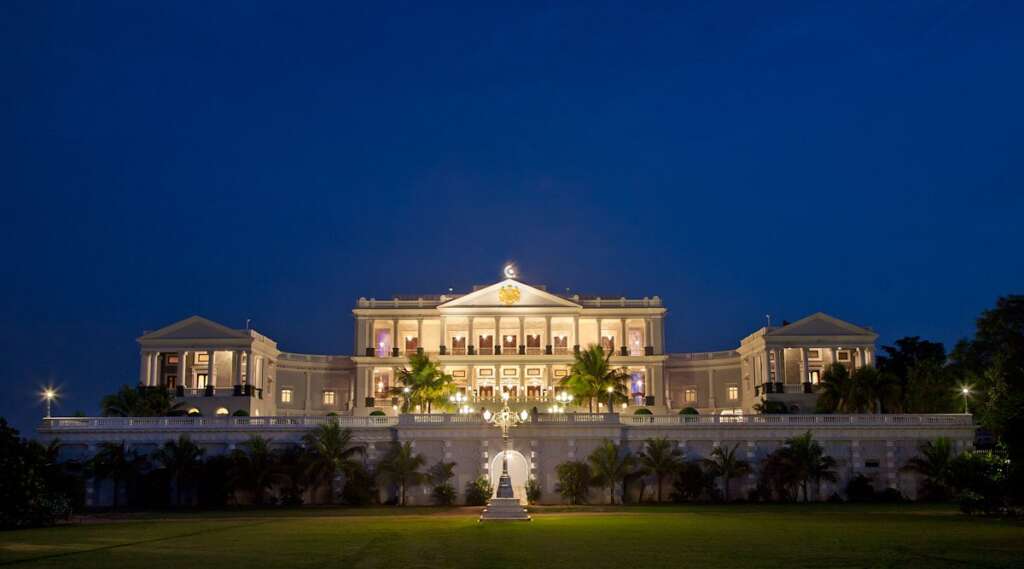 Grand European-style façade of Taj Falaknuma Palace with Corinthian columns, marble staircases, and expansive terrace views of Hyderabad.