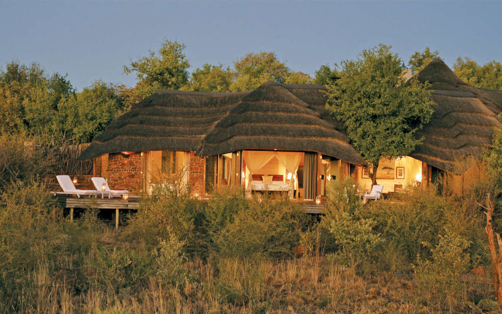 a sustainable home with modern furniture, natural light streaming through large windows, and solar panels on the roof, emphasizing eco-friendly living