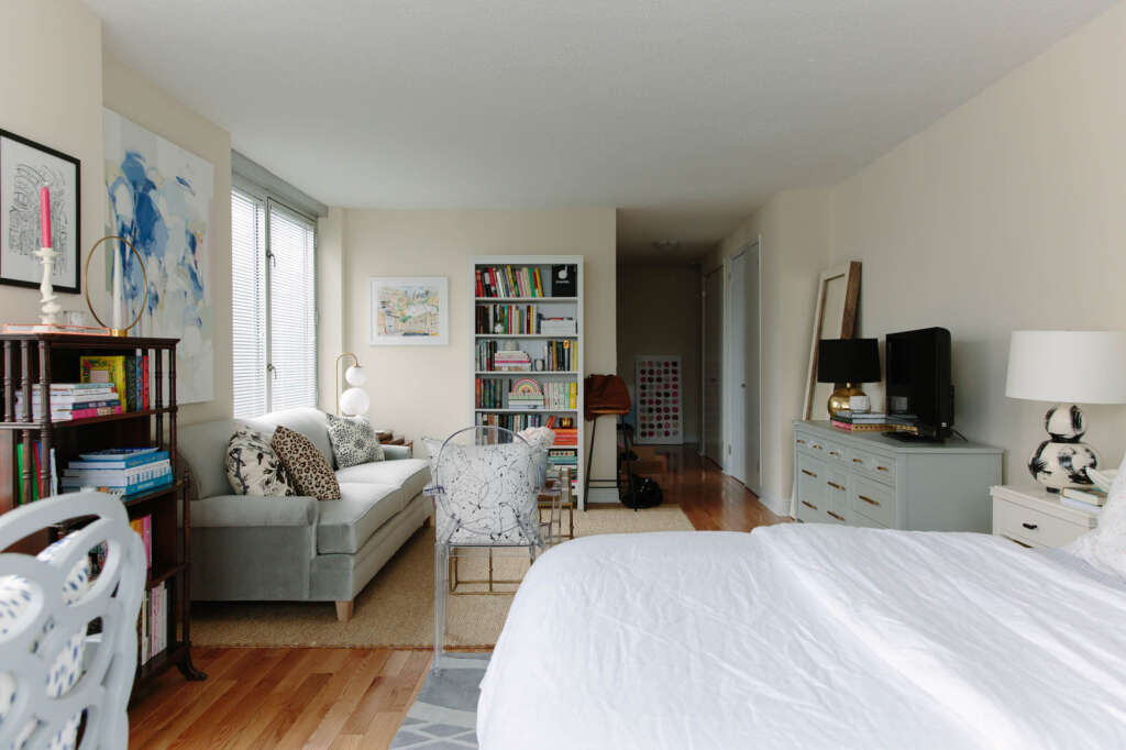 A compact studio apartment featuring multifunctional furniture, such as a bed and a space-saving dining table